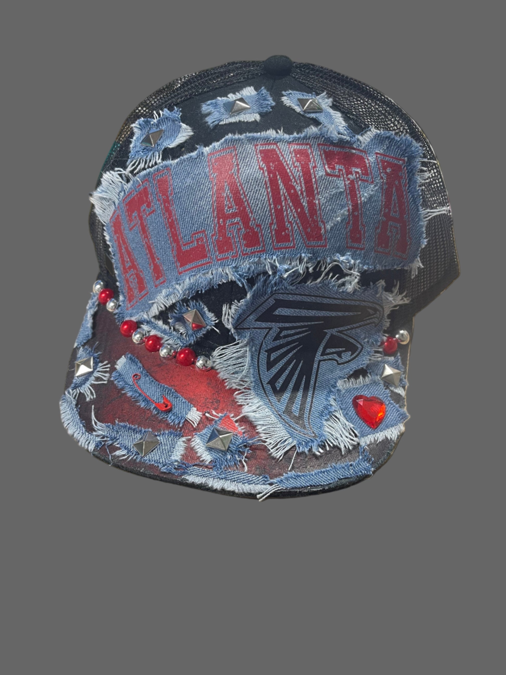 Denim patch with 'Atlanta' text and falcon design on a table with scissors and other items.