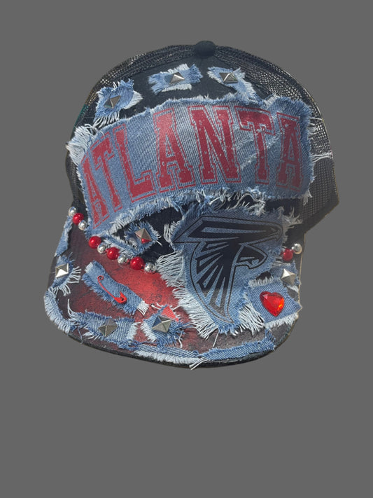 Denim patch with 'Atlanta' text and falcon design on a table with scissors and other items.
